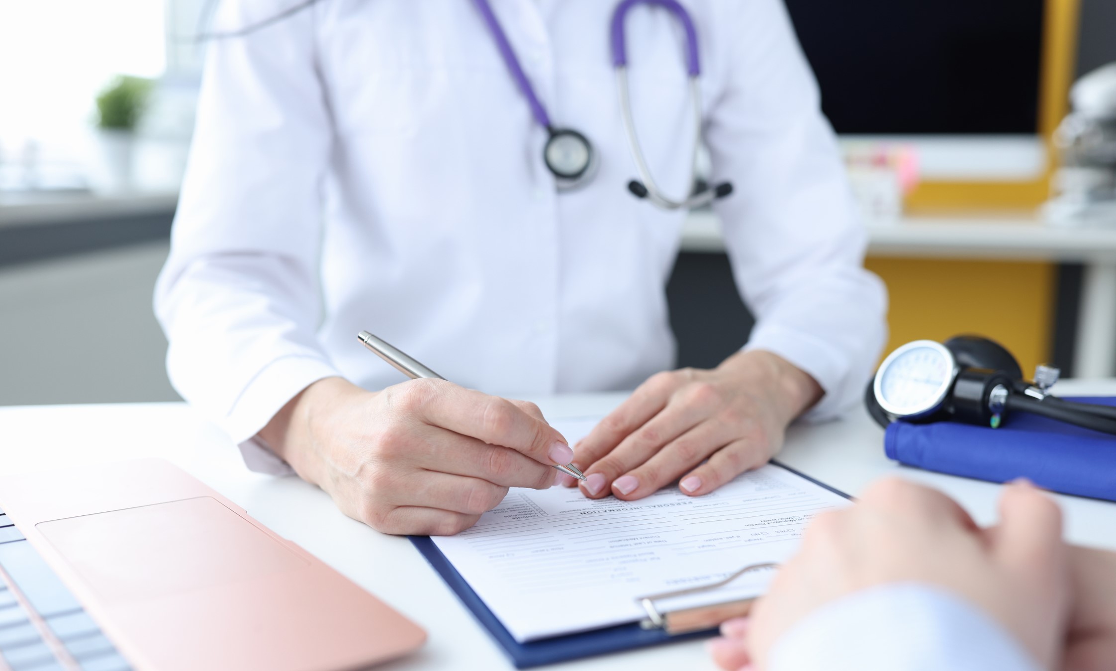 A doctor and a patient in a doctor's office with a clipboard